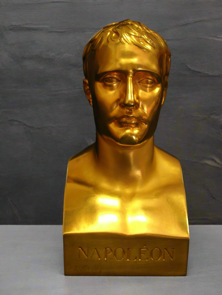Gold bust of a historical figure on a gray background