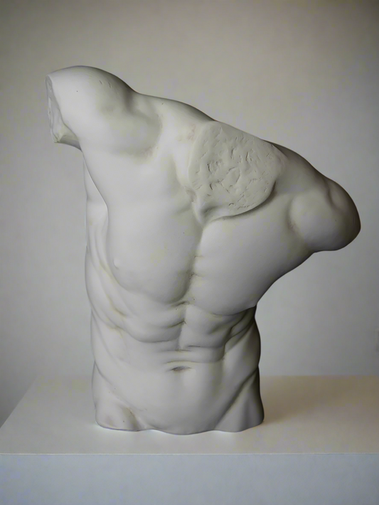 A sculpture of a large male torso made from marble, displayed against a black background.