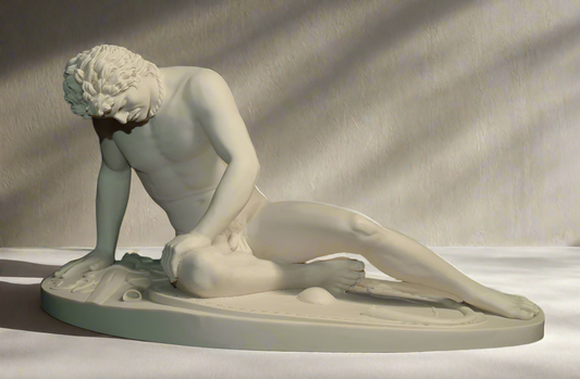 Statue of a nude figure on a plain background