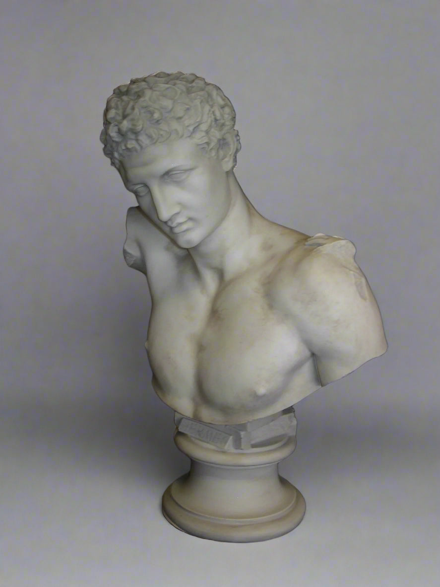 A marble bust sculpture of the Greek god Hermes, holding the infant Dionysus, with a black background.