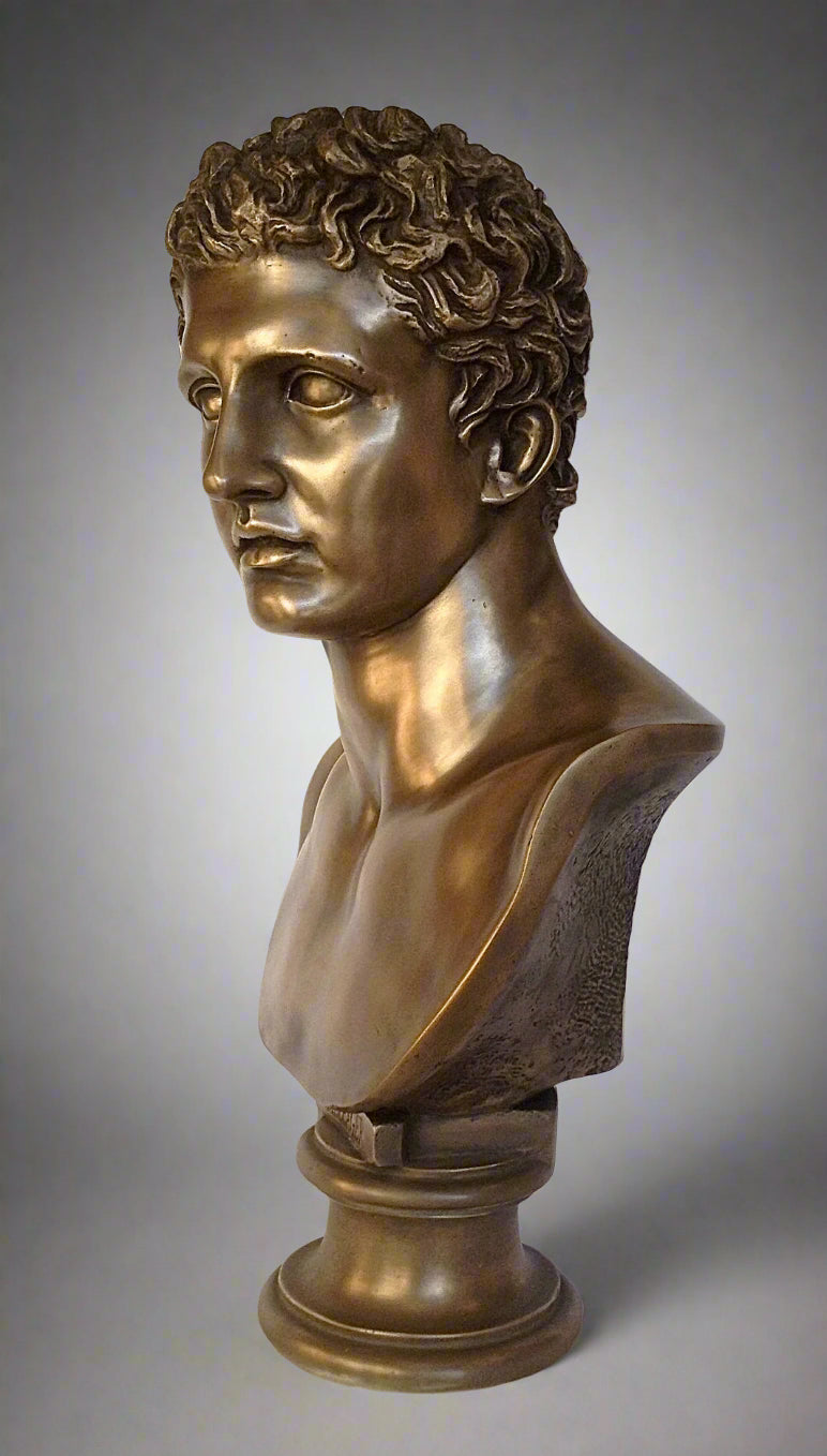 Bronze bust of a classical figure on a gray background