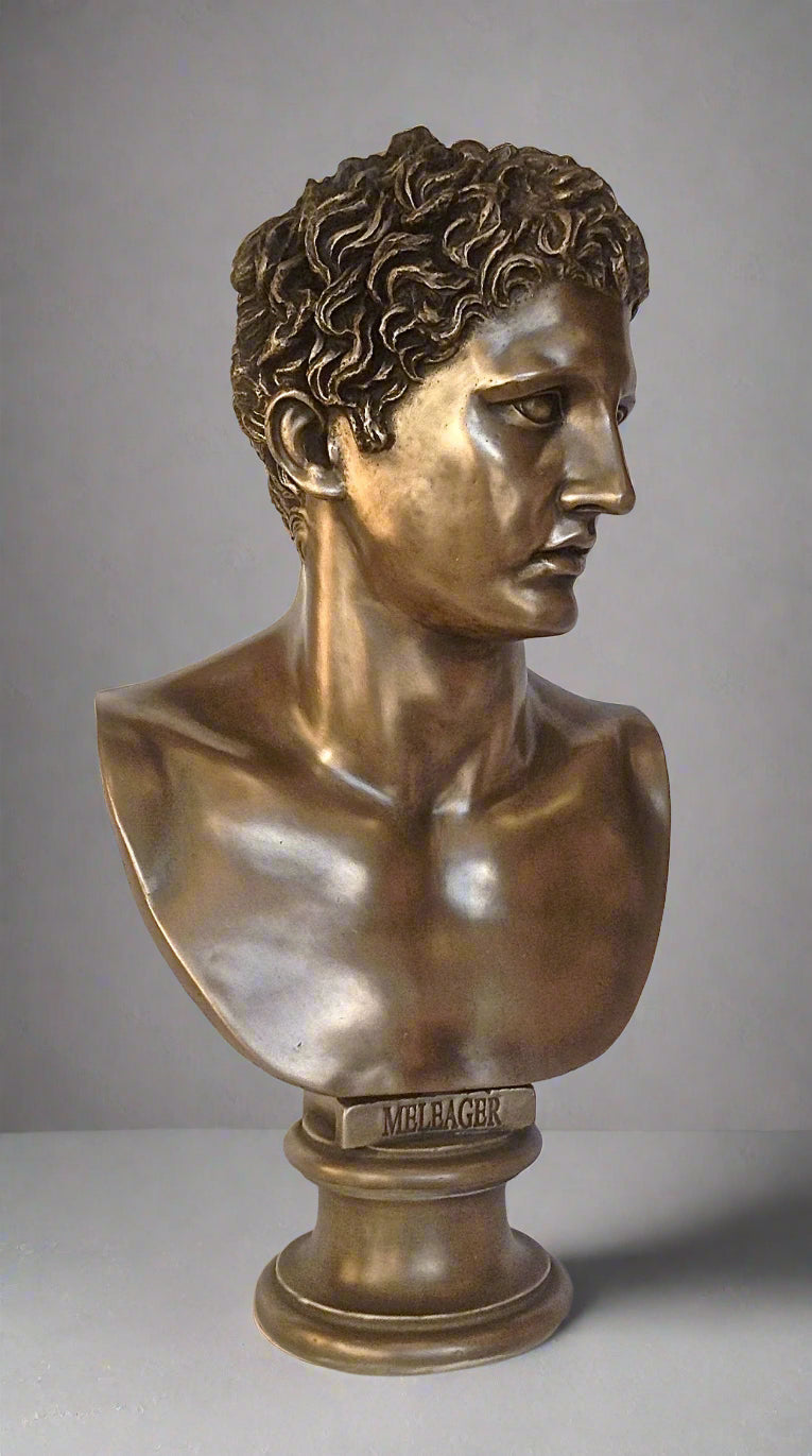 Bronze bust of a classical figure on a gray background