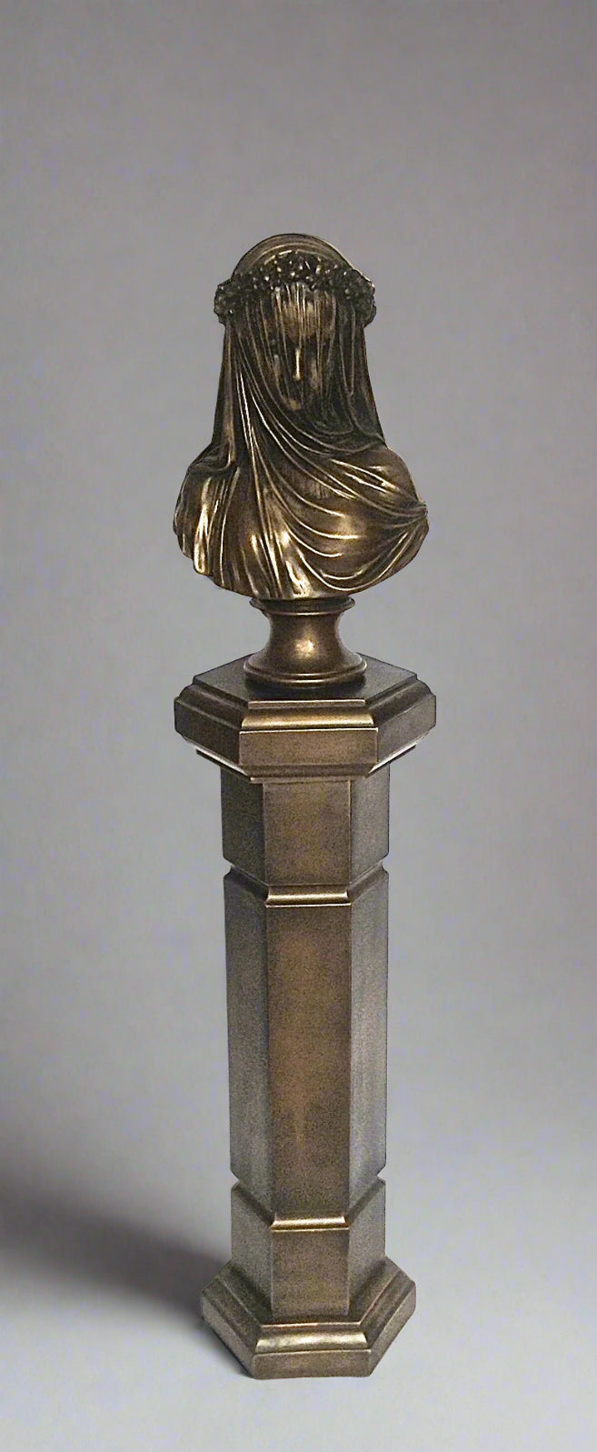 Bronze bust on a pedestal against a gray background