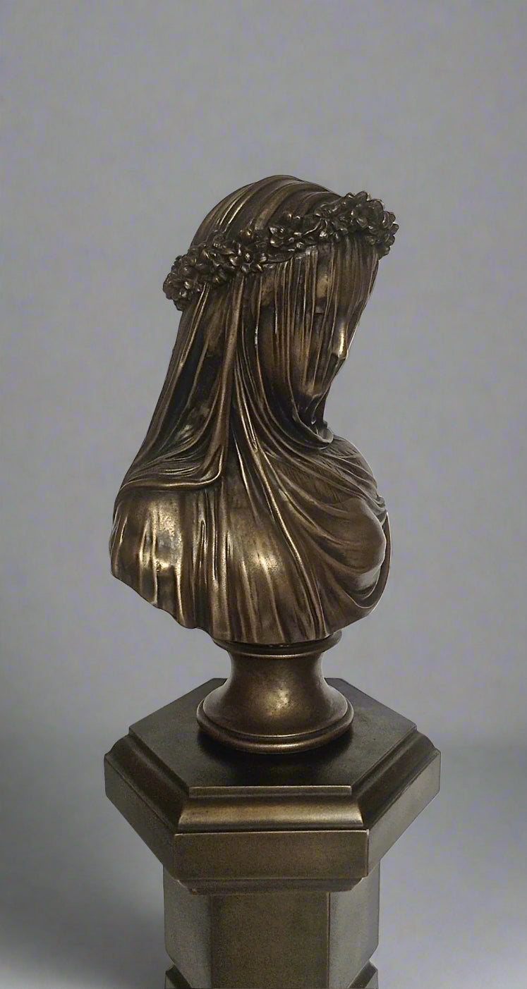 Bronze bust of a draped figure with a wreath on a gray background
